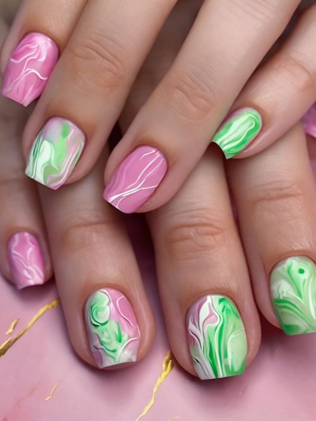 A close up of pink and green nails featuring a vibrant nail design.