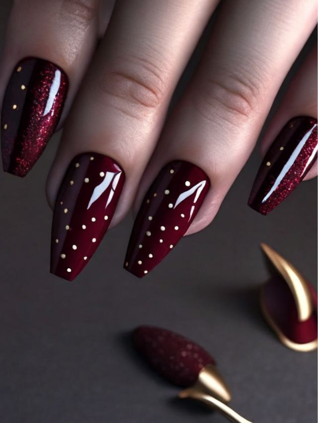 A woman with burgundy nails adorned with gold polka dots, showcasing cute fall toe nail designs.