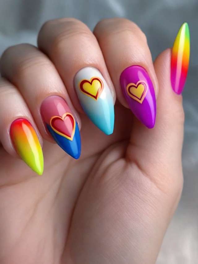 A woman holding a colorful nail with hearts on it.