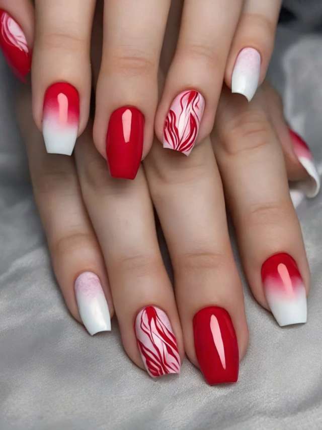 A woman with red and white nails with designs on them.