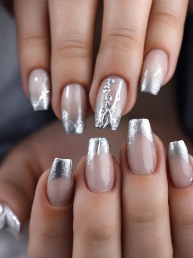 A woman's hands with silver nail designs.