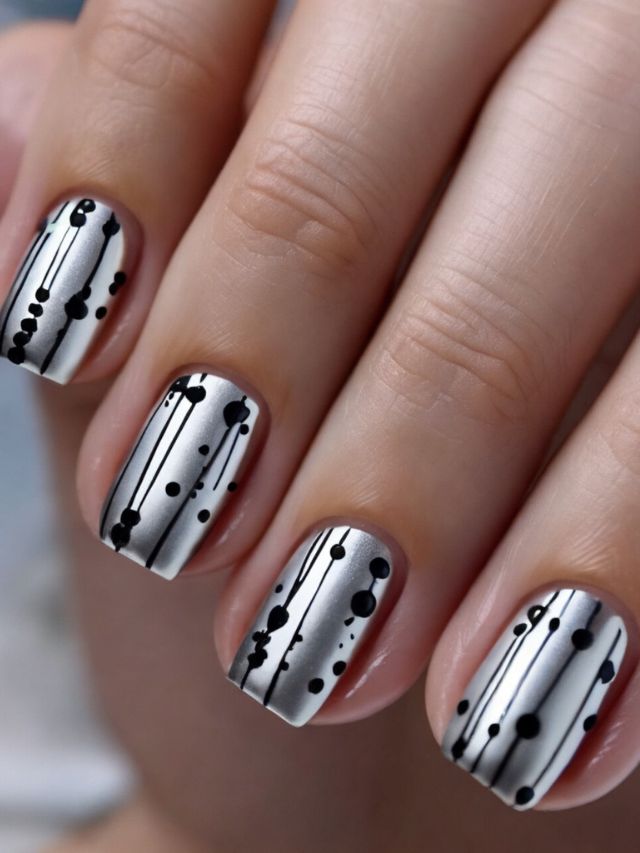 A woman's nails with black and white dots on them.