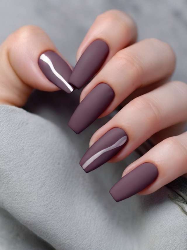 A woman's hand is holding a purple nail with a silver stripe.