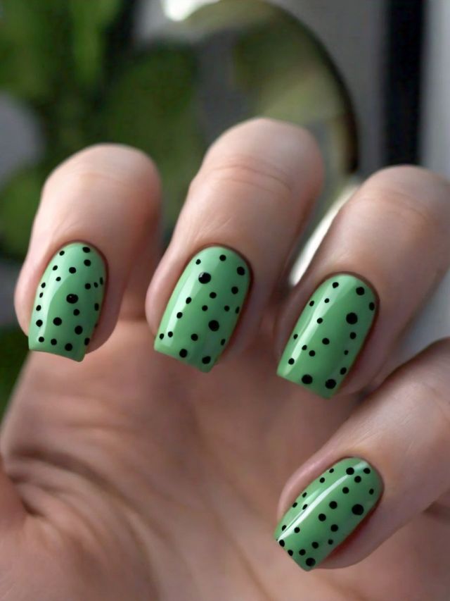 St Patrick's Day-inspired nail art featuring green and black polka dots for extra luck.