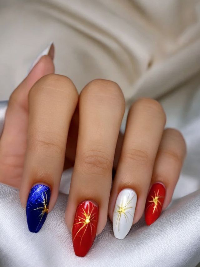 A woman with cute red, white and blue nails with fireworks on them.