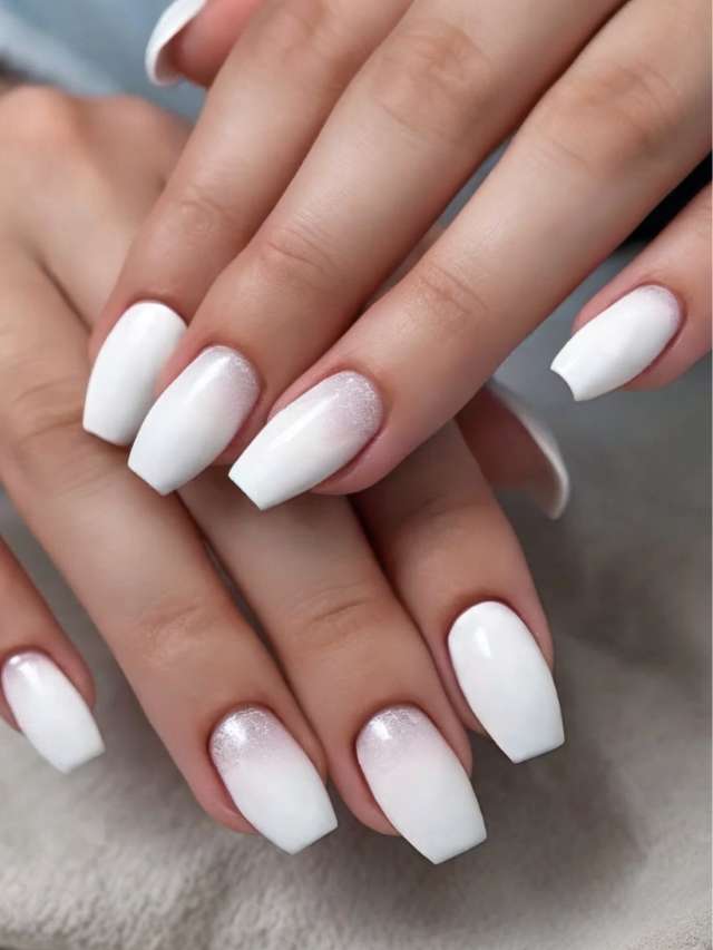 A woman's hands with white nail polish on them.