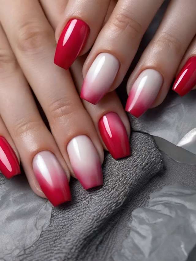 A woman's hands with red and white ombre nails.
