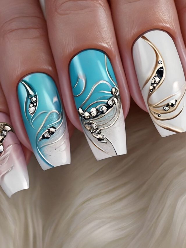 A woman's nails with white, blue and gold designs.