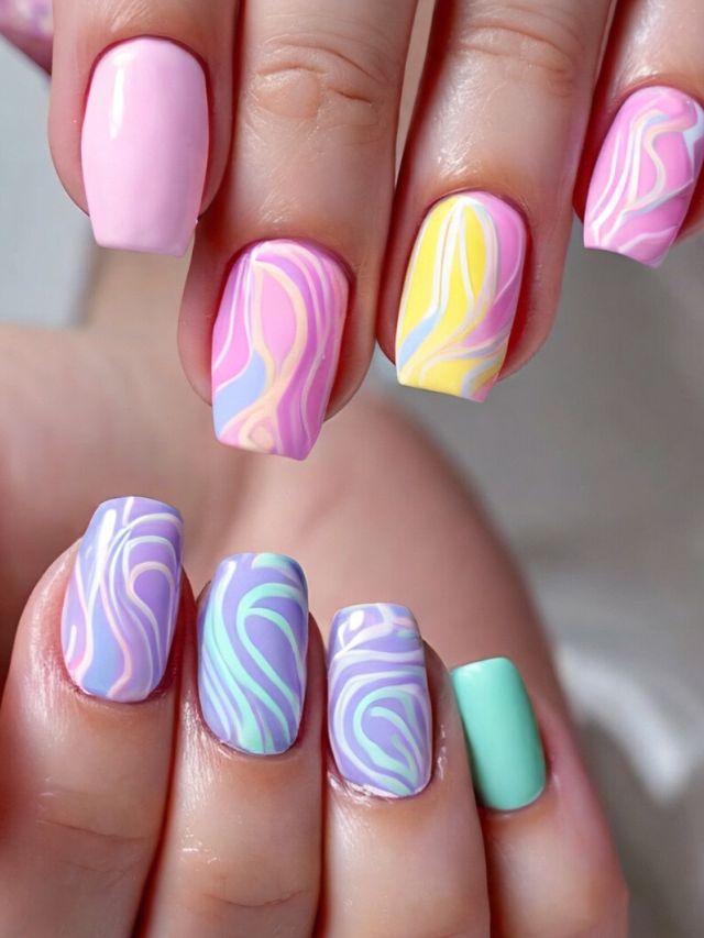A woman's hand with colorful marbled nails.
