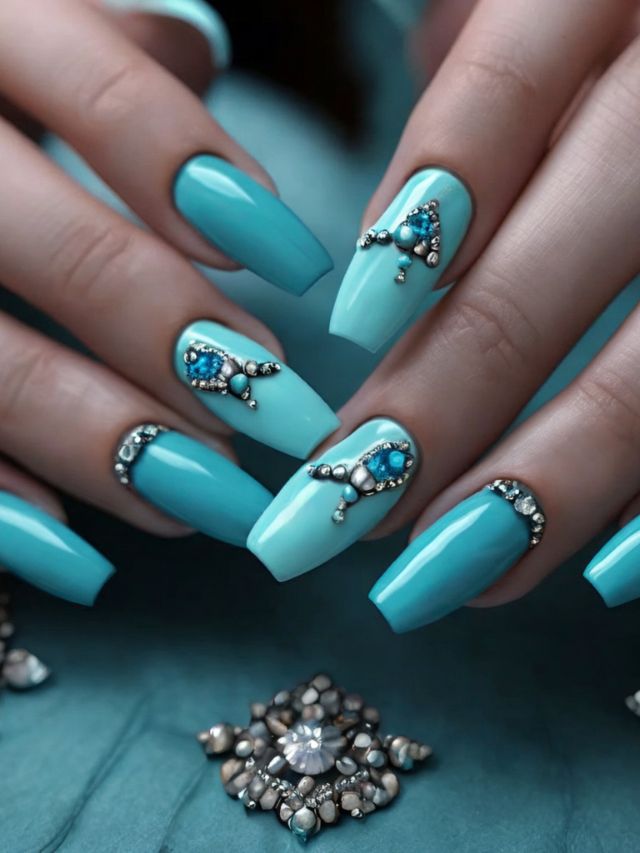 A woman's hands with blue nails and jewels on them.