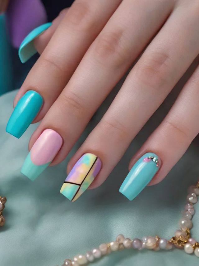A woman's hand with a blue, pink, and green manicure.