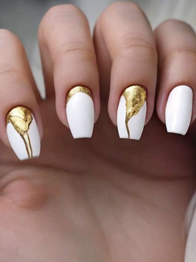 A woman with white and gold nails.
