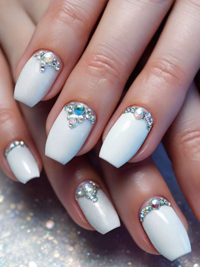 White nails with rhinestones on them.